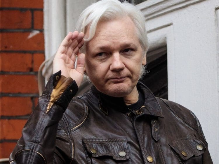 Julian Assange saluting outside extradition