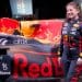 Female Red Bull Racing employee stands in front of race car.