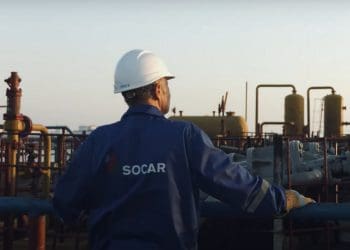 Azerbaijan state fossil fuel company SOCAR employee looks out across an industrial oil and gas site.