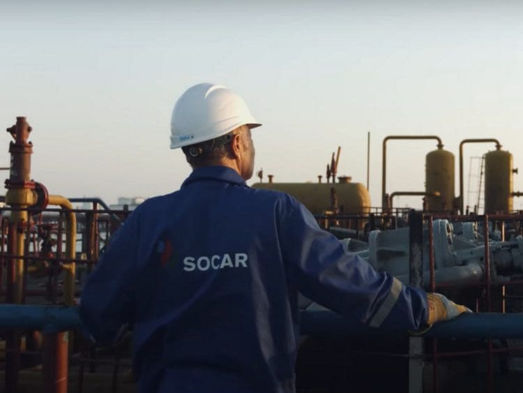 Azerbaijan state fossil fuel company SOCAR employee looks out across an industrial oil and gas site.