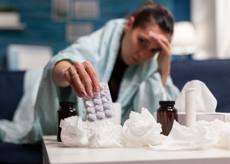 Statutory sick pay woman holding tablets looking sick
