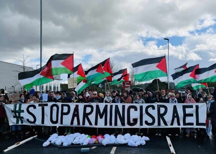 Stop Arming Israel banner being held by people outside Elbit factory in Bristol