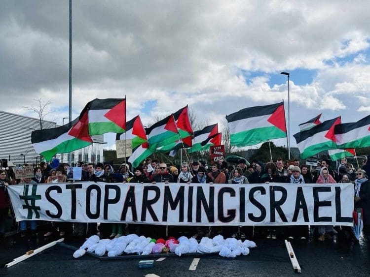 Stop Arming Israel banner being held by people outside Elbit factory in Bristol