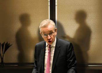 Michael Gove in front of two shadowy figures leaseholders