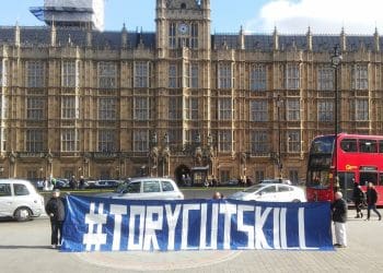 parliament protest with a banner that says tory cuts kill. fuel poverty