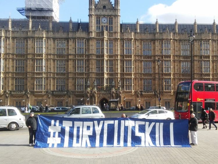 parliament protest with a banner that says tory cuts kill. fuel poverty