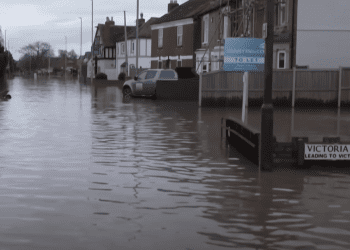 Flooding down a UK residential street climate insurance weather