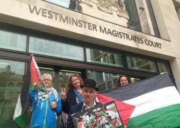 Neil Goodwin with supporters outside court with the Palestinian flag Israel
