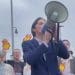 Protesters with a megaphone and Shell burning logos singing outside the company's AGM Shell AGM climate