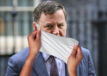 Mel Stride with a wet wipe over his face DWP