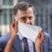 Mel Stride with a wet wipe over his face DWP
