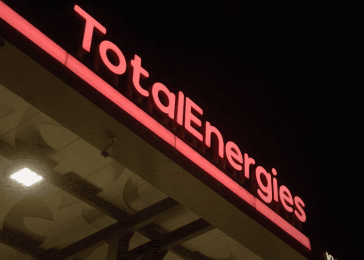 TotalEnergies logo in neon lights on a petrol station.