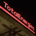 TotalEnergies logo in neon lights on a petrol station.