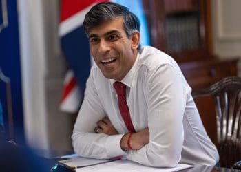 Rishi Sunak laughing at a desk with a Union Jack flag behind him DWP benefit fraud Private Eye