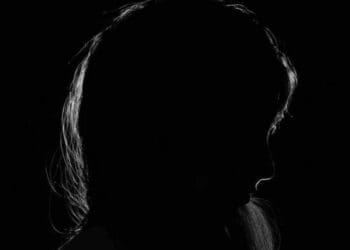 ME/CFS the shadow of a woman's face in a dark room