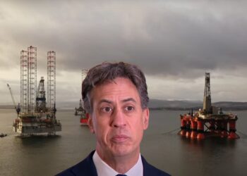 Ed Miliband with three offshore oil rigs behind him Rosebank