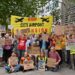Protesters gather with banners and placards which read: "Stop City Airport Expansion", "Revoke the decision", "They fly, we choke", and "Ban expansion, not protest" London City Airport Labour