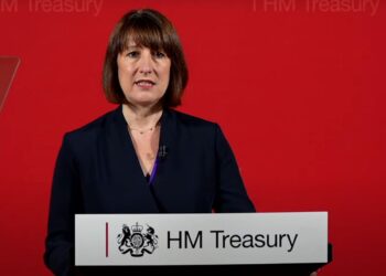 Chancellor Rachel Reeves standing at a HM Treasury podium winter fuel payment