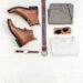 a pair of leather boots and some men's accessories lying on a white table
