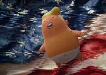Fragmented US flag, with Trump baby blimp flying in front of it.