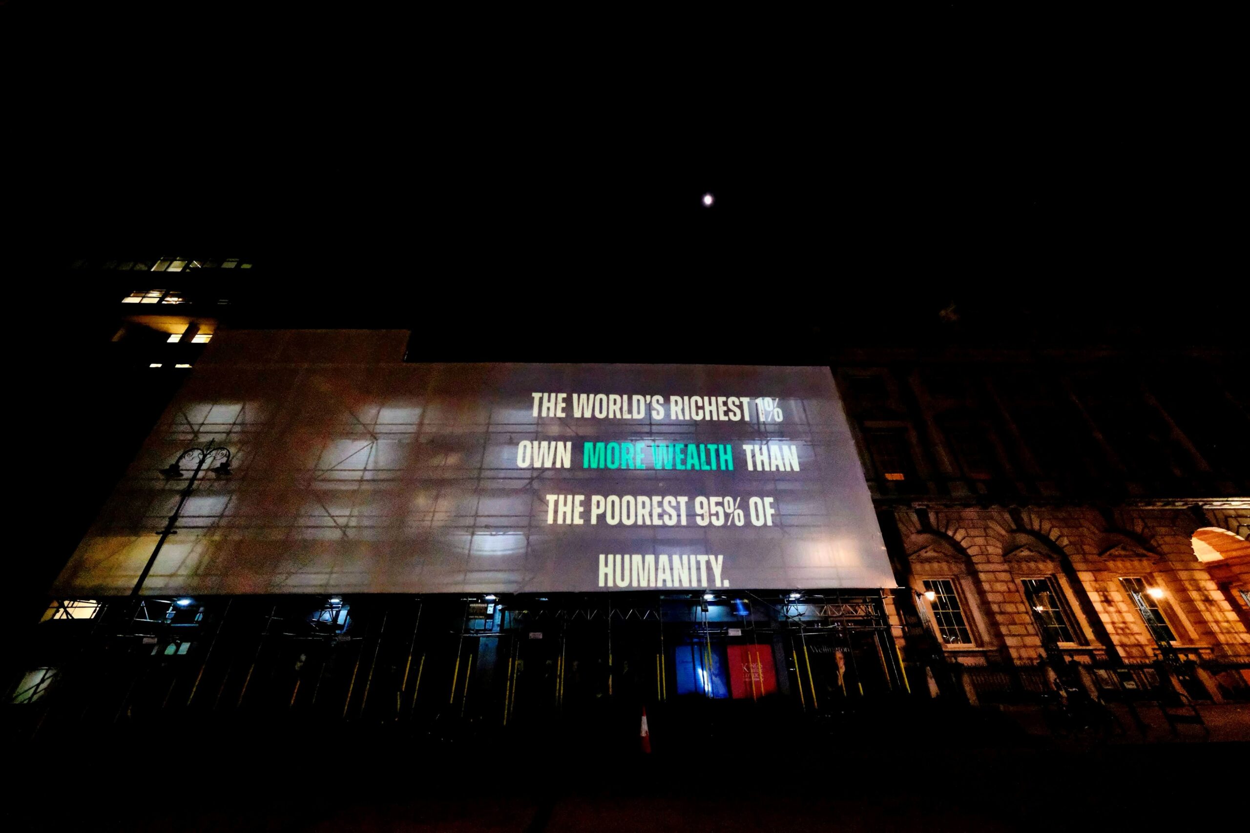 Projection at the Strand which reads: "The world's richest 1% own more wealth than the poorest 95% of humanity."