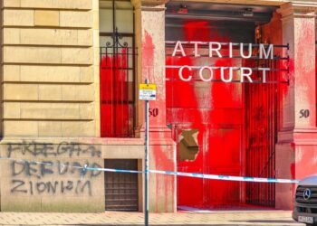 Spray-painted message on the entrance to Atrium Court reads "Free Gaza: defund Zionism". Red paint all over the front entrance, with police cordon stretching out in front.