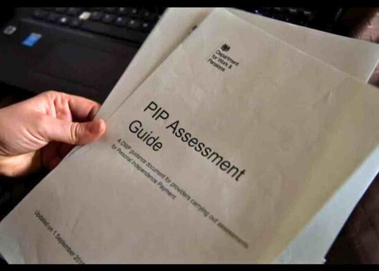 DWP: Someone holds a printed copy of a PIP assessment guide in their fingertips