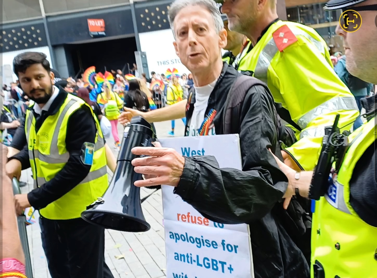 Three police officers removing Tatchell from the Pride parade. 