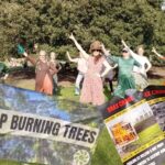 Nine women strike a pose while dancing on the grass, with trees behind, in Princes Street Gardens, Edinburgh. Stop burning trees banner and Drax crime posters superimposed over the top Drax AGM