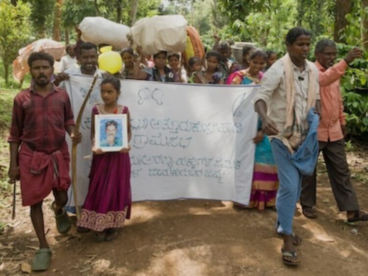 Jenu Kuruba families begin their long-awaited re-occupation of their ancestral homes inside the Nagarhole National Park. They carried photos of loved ones who had died after the village was evicted, so they too can return to the forest.