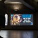 Billboard at Platform 2, Eastbound on the District Line at Westminster Station with a beagle puppy peering out from behind bars and text reading: Research. Time for some 'out of the cage thinking' with PETA's logo.