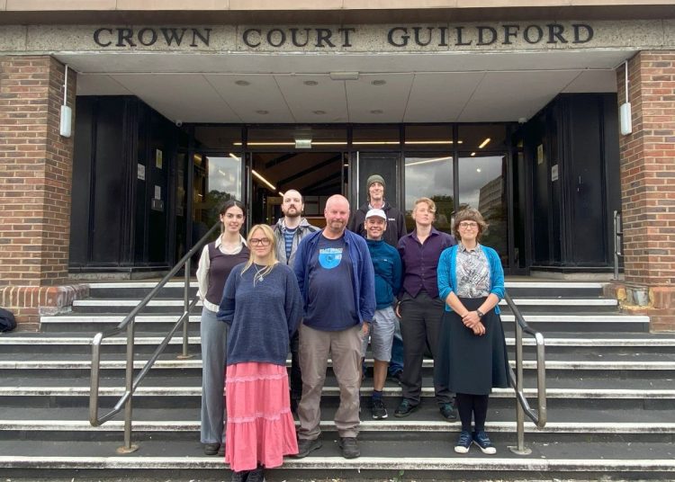 Group of Just Stop Oil activists standing trial stood outside 'Crown Court Guildford'.