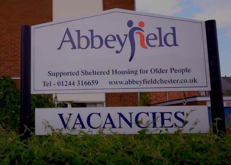 Abbeyfield Chester sign outside residences, reading: "Supported Sheltered Housing for Older People" with the telephone number and website for Abbeyfield Chester, and "VACANCIES" beneath.