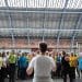 Climate Choir in the station singing together in a large crowd. Person with her back to the photo conducting the choir.