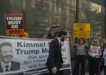 People protesting Jimmy Kimmel's axing, with a banner that reads: "Kimmel stays, Trump must go!"