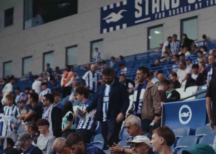 Samaritans and Bright & Hove Albion video. Football fans in the stands, with two men walking to their seats.