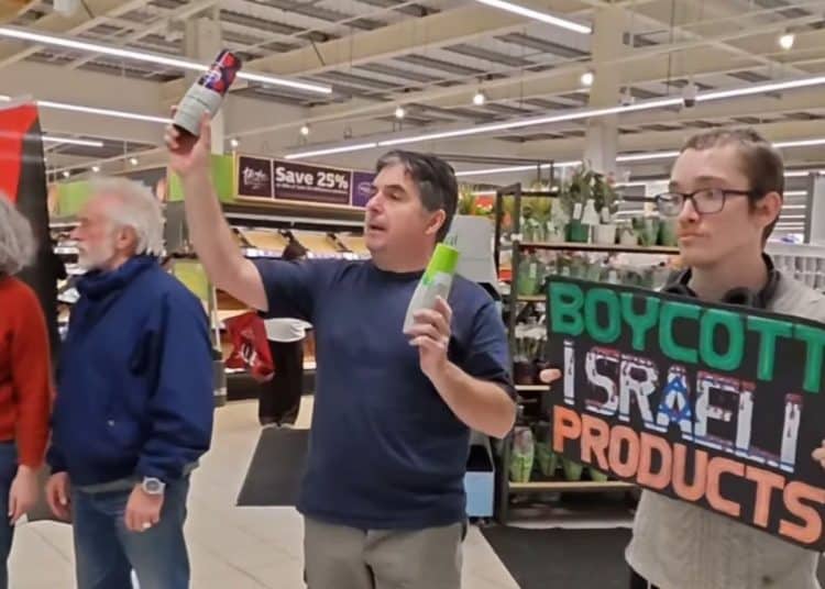 Palestine activists stand in a Sainsbury's store holding products made in Israel with a sign saying "Boycott Israeli products" Belfast