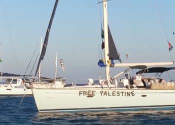 Global Sumud Flotilla vessels sail towards Gaza with 'Free Palestine' on the hull, and Palestine flags.