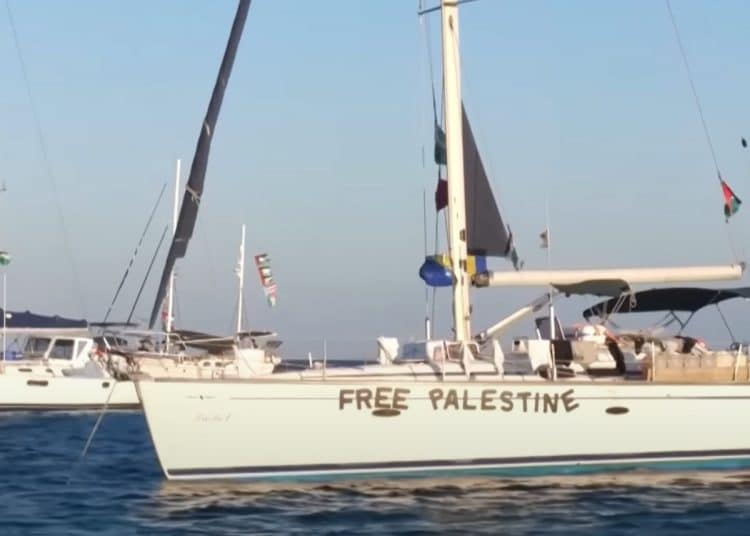 Global Sumud Flotilla vessels sail towards Gaza with 'Free Palestine' on the hull, and Palestine flags.