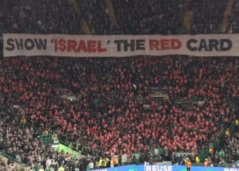 Football fans in a stadium hold an enormous banner which reads: "Show Israel the red card" Israel FIFA UEFA ban