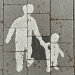 Family courts law change - image of an adult holding a child's hand painted on to the concrete
