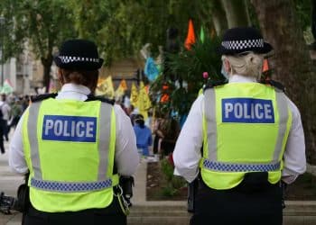 Stop and search - two uniformed police officers walking with their back to the camera