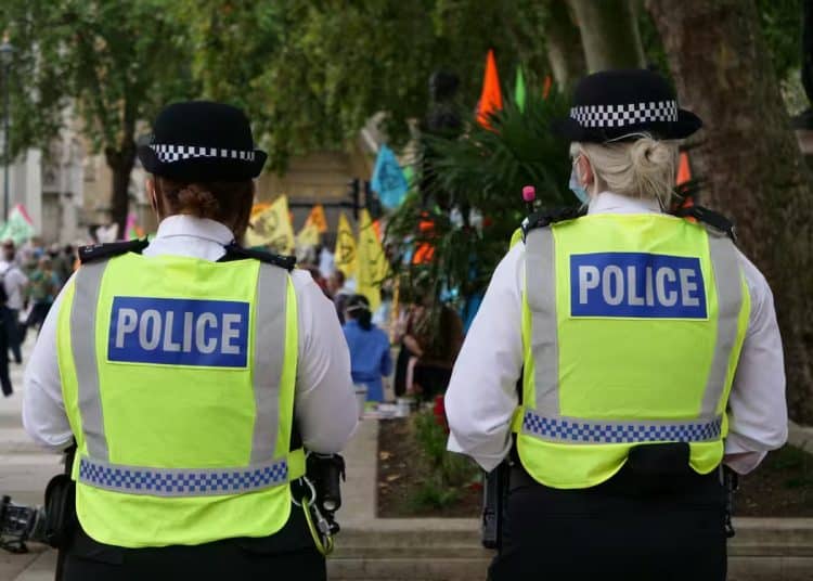 Stop and search - two uniformed police officers walking with their back to the camera