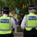 Stop and search - two uniformed police officers walking with their back to the camera