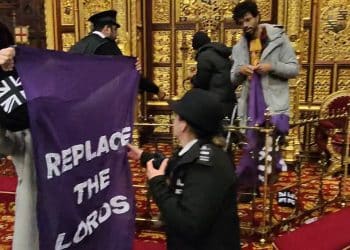 P:rotestors in house of lords hold a banner saying Replace The Lords