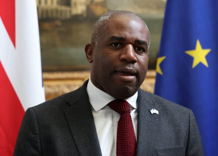 David Lammy in front of a union flag and a European Union flag
