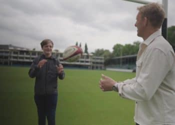 Lewis Moody passes a rugby ball to a boy called Jake who lives with a stoma