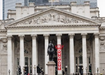 The Royal Exchange building in London with a red banner saying Boycott hung from a pillar by activists from Boycott Bloody Insurance