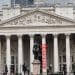 The Royal Exchange building in London with a red banner saying Boycott hung from a pillar by activists from Boycott Bloody Insurance