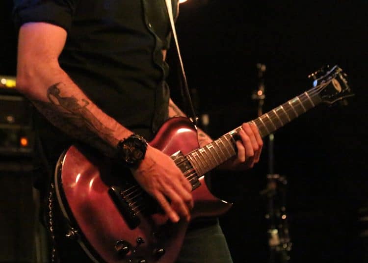 Close up of a person playing electric guitar